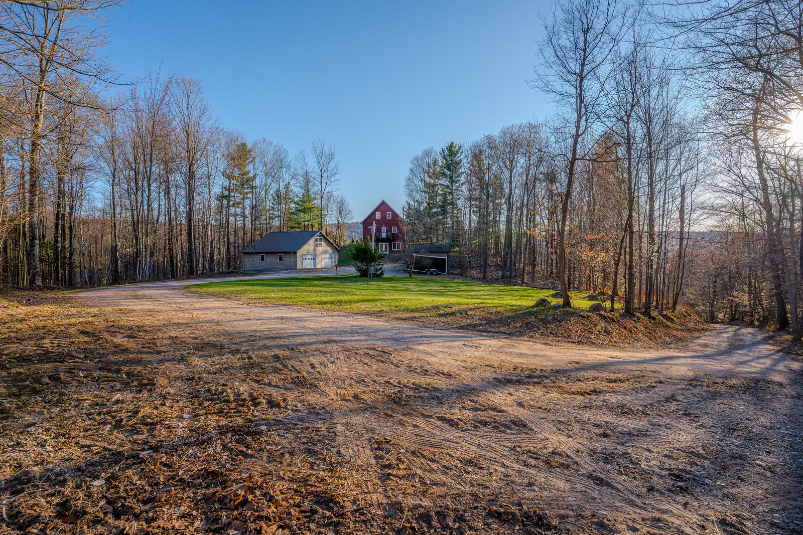 Wide property arrival, dirt road, late-day rake light