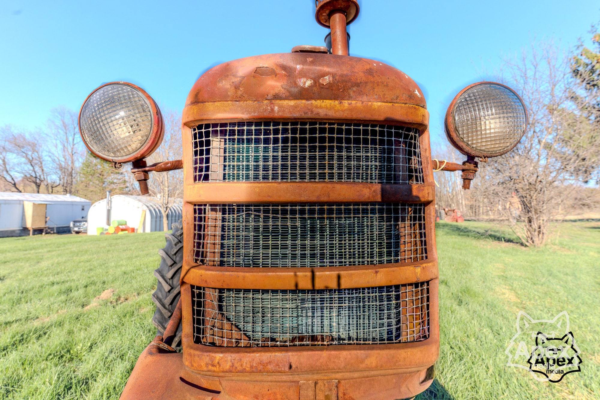 Rusted orange tractor grille front-on, dramatic patina